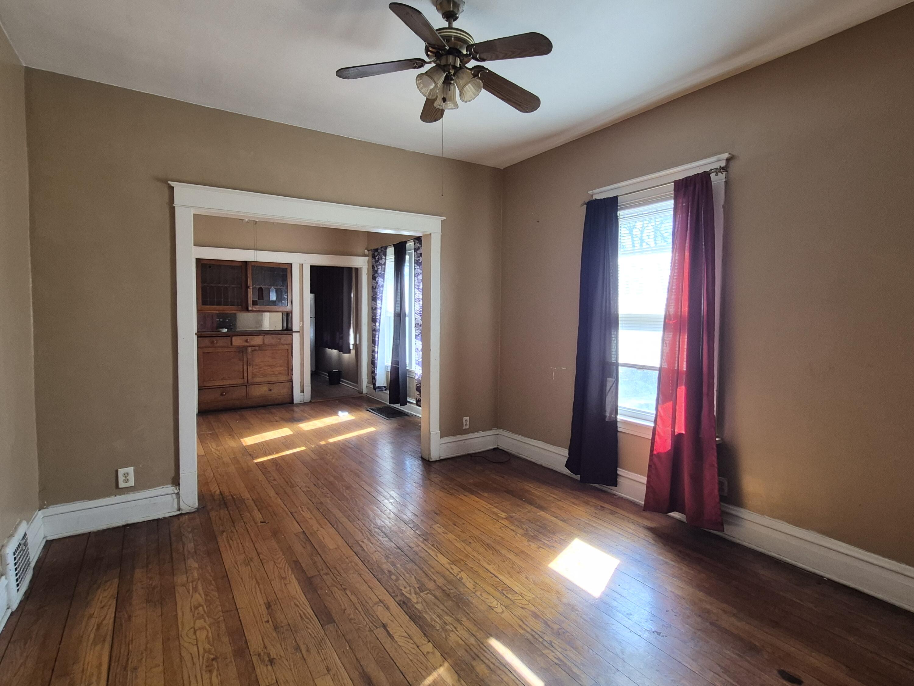 395 Porter Street Gary, IN 46406 - Photo 5 of 14 a view of a livingroom with wooden floor and a ceiling fan