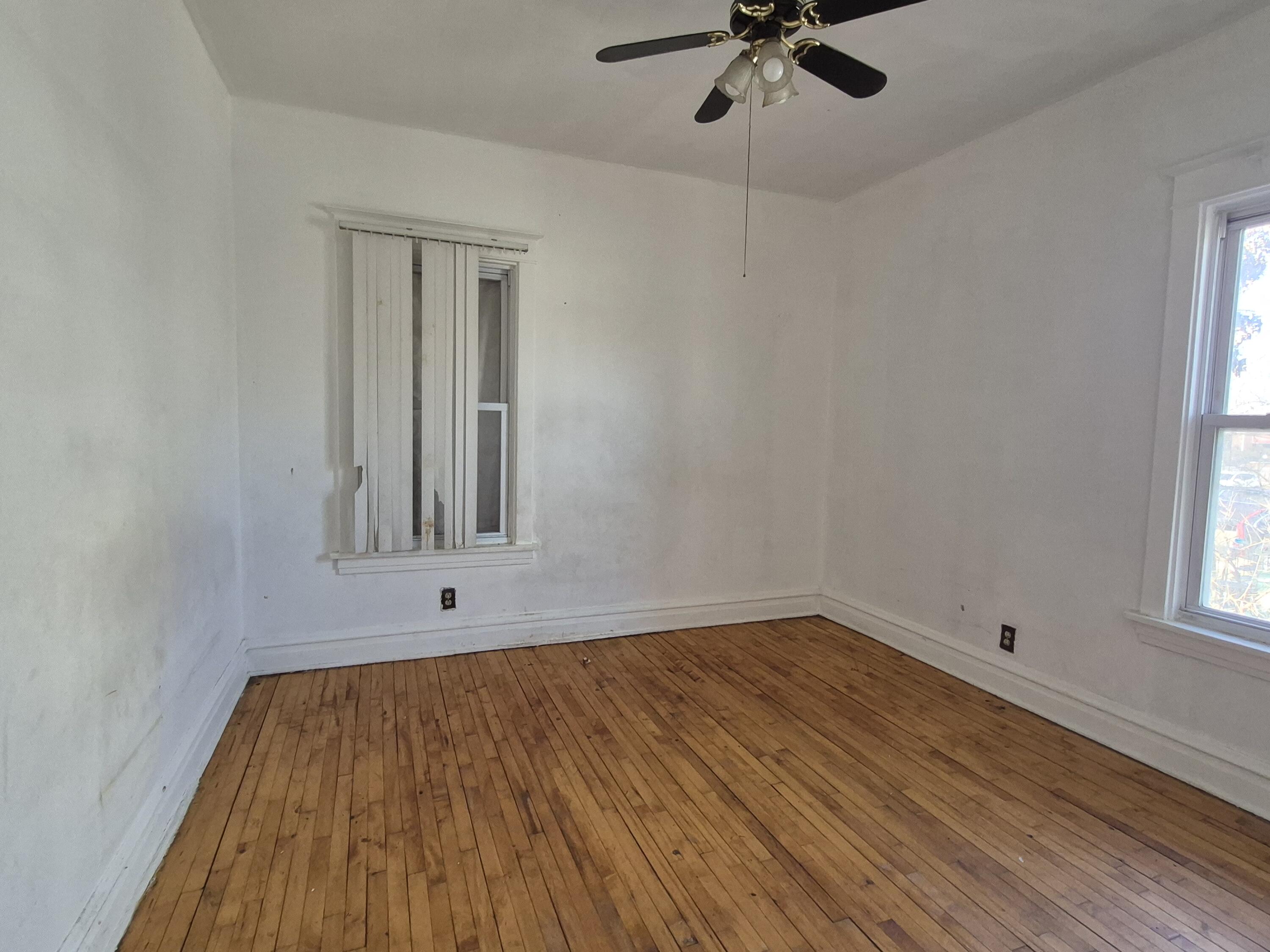 395 Porter Street Gary, IN 46406 - Photo 8 of 14 wooden floor in an empty room with a window