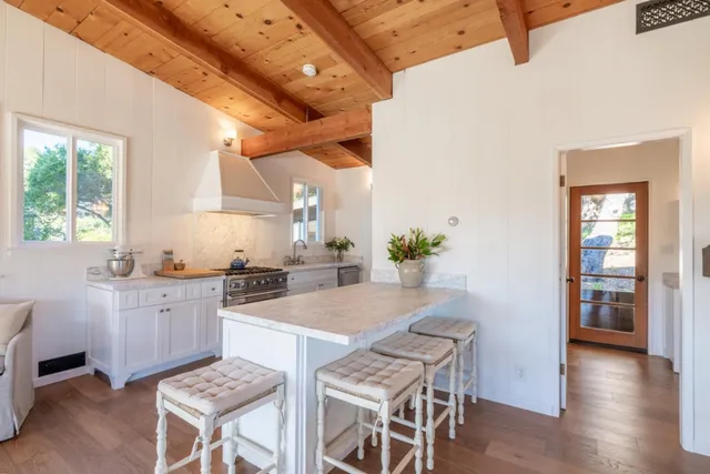 a view of a patio with table and chairs a barbeque with wooden floor and roof with floor to ceiling window