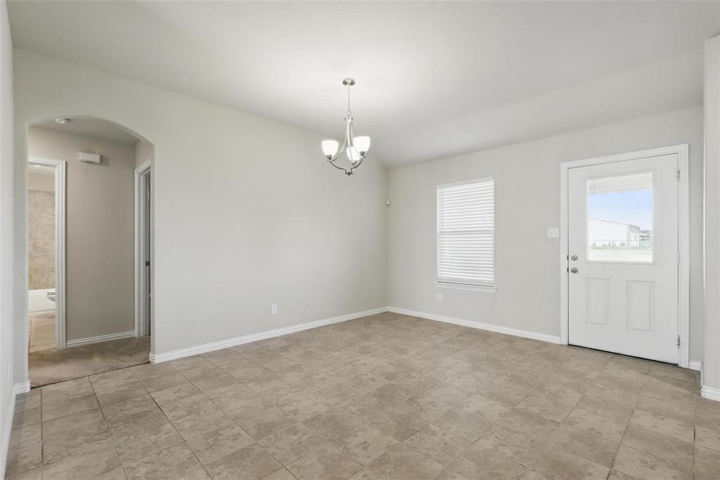 240 Springwood Ranch Loop Springtown, TX 76082 - Photo 11 of 27 an empty room with chandelier fan and windows