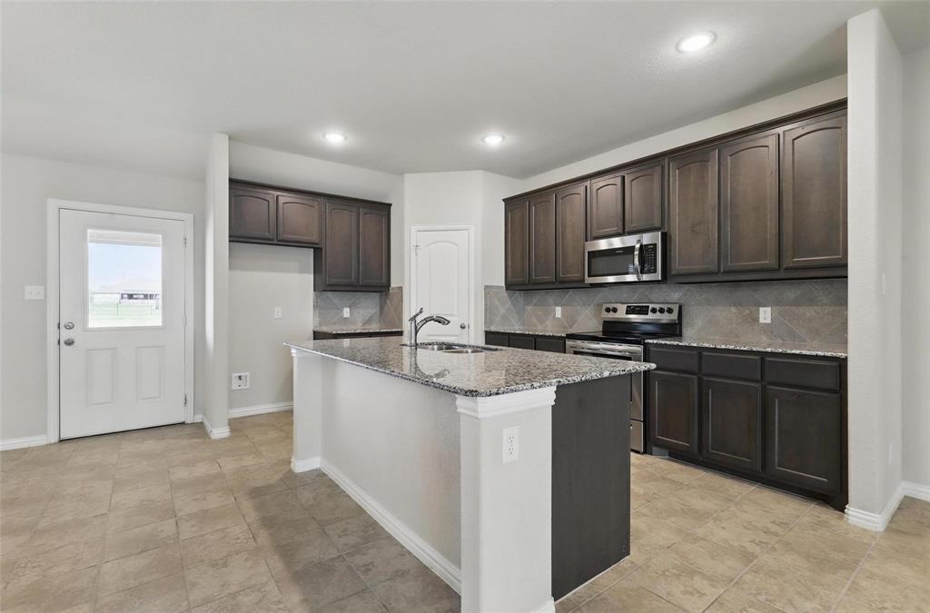 240 Springwood Ranch Loop Springtown, TX 76082 - Photo 8 of 27 a kitchen with stainless steel appliances granite countertop a refrigerator stove microwave and sink