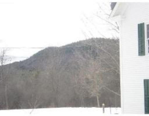 823 Orange Road Warwick, MA 01378 - Photo 2 of 8 a view of a dry yard with mountains in the background