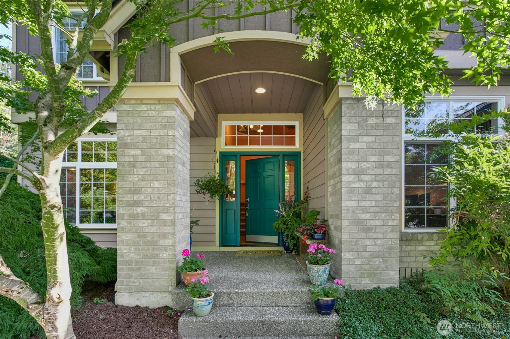19033 29th Avenue Southeast Bothell, WA 98012 - Photo 5 of 40 a view of a brick house with a large windows and flower plants