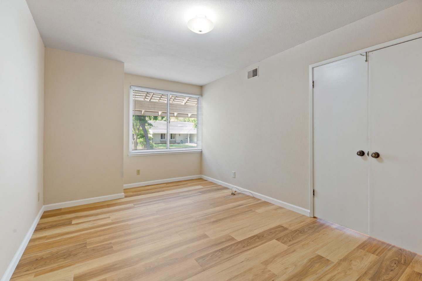 7034 Vía Pradera San Jose, CA 95139 - Photo 15 of 31 a view of an empty room with wooden floor and a window
