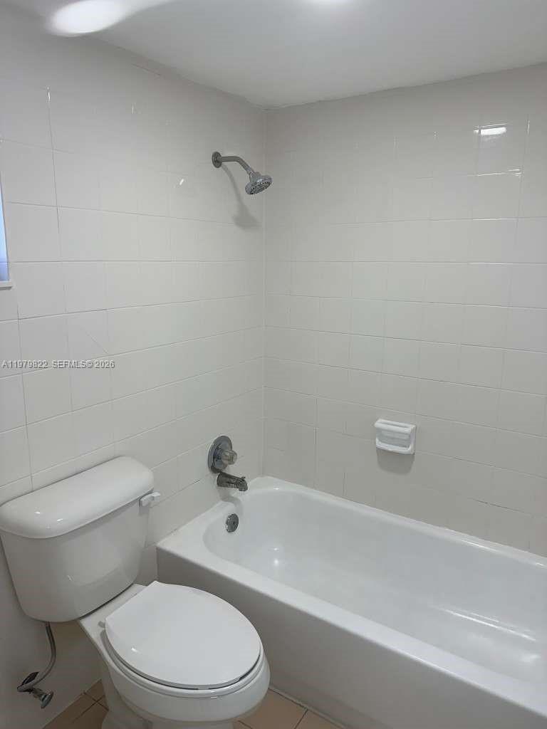 7355 West 4th Avenue, Unit 216 Hialeah, FL 33014 - Photo 3 of 7 a white toilet and a bath tub sitting in a bathroom