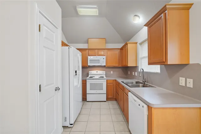 a kitchen with stainless steel appliances granite countertop a sink and a refrigerator