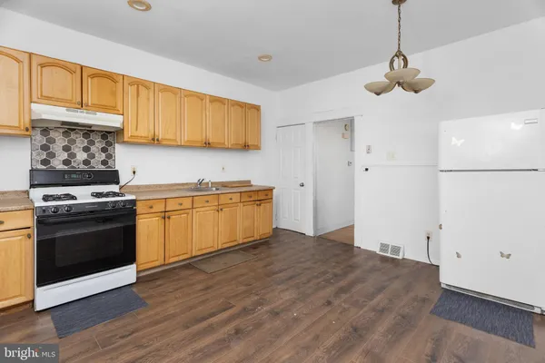 a kitchen with a stove cabinets and wooden floor