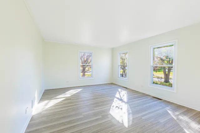 a view of empty room with window and wooden floor