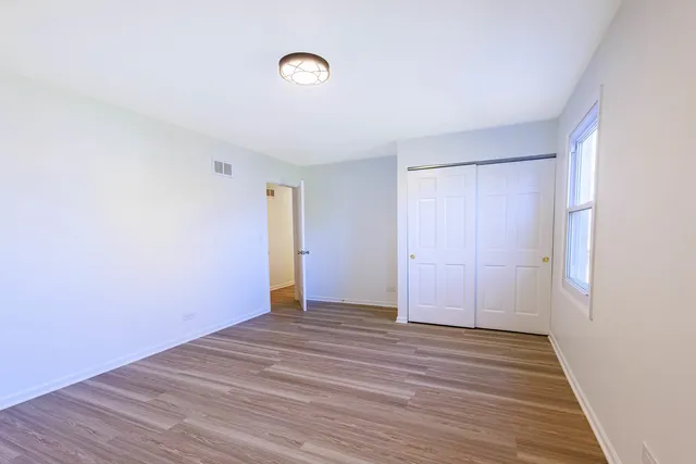 an empty room with wooden floor and window