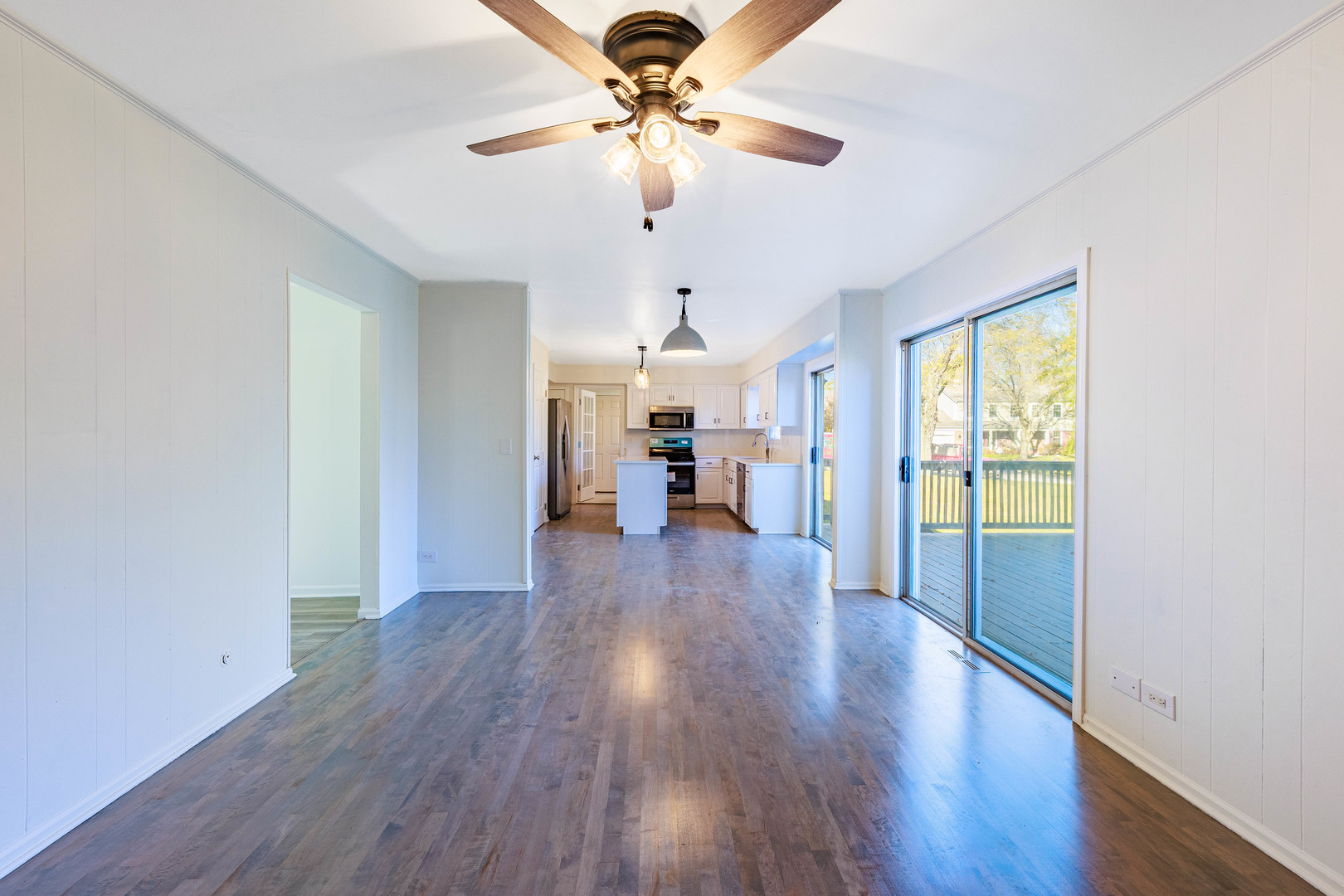 1224 West Whytecliff Road Palatine, IL 60067 - Photo 6 of 50 a view of a livingroom with wooden floor a ceiling fan and windows