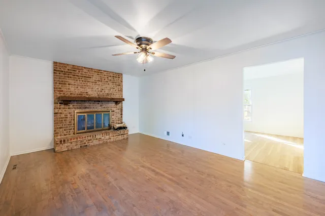 a view of an empty room with a fireplace and a window