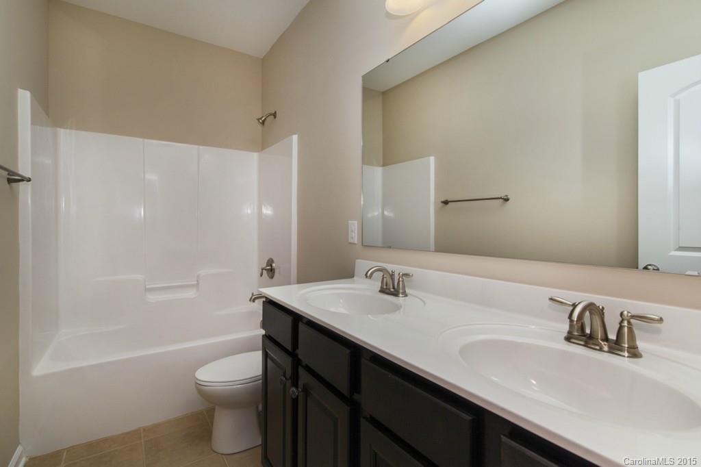 710 Old Cove Road, Unit 42 Tega Cay, SC 29708 - Photo 18 of 23 a bathroom with a granite countertop sink toilet and shower