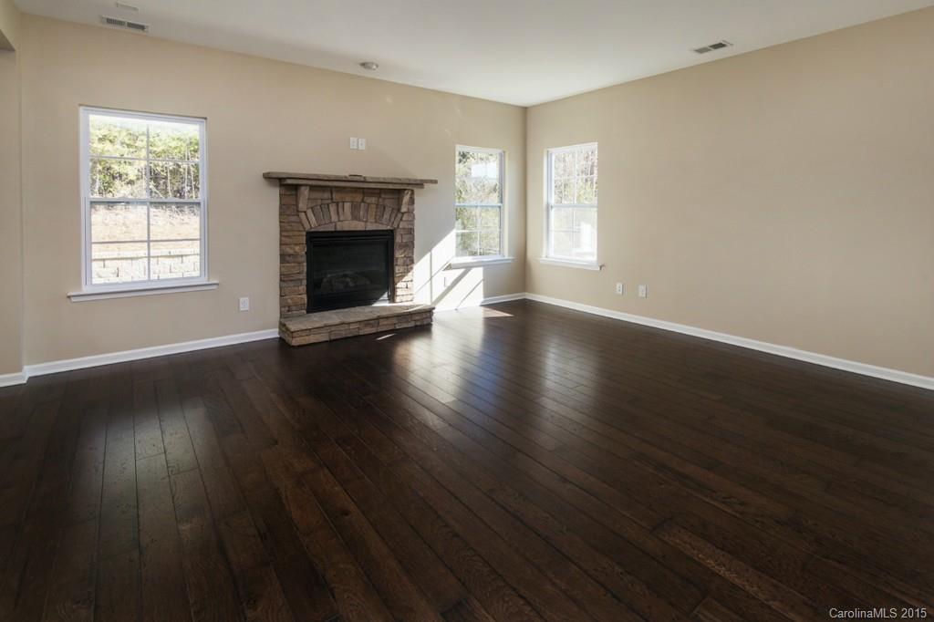 710 Old Cove Road, Unit 42 Tega Cay, SC 29708 - Photo 5 of 23 an empty room with wooden floor fireplace and windows