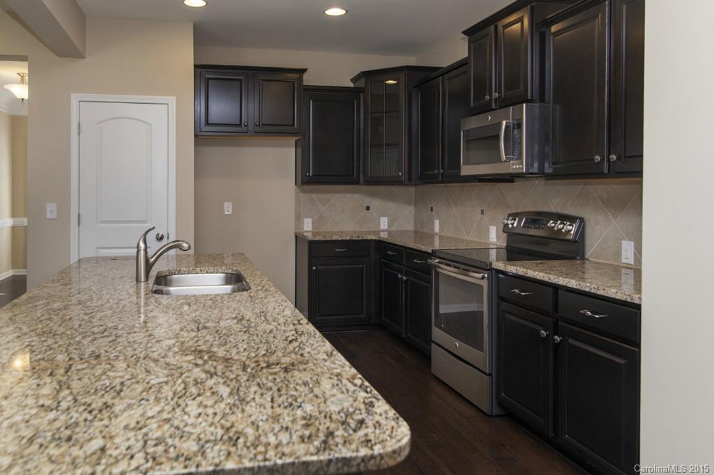 710 Old Cove Road, Unit 42 Tega Cay, SC 29708 - Photo 7 of 23 a kitchen with stainless steel appliances granite countertop a sink stove and microwave