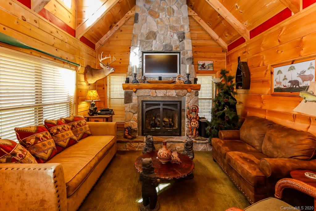 997 Proctor Road Lake Lure, NC 28746 - Photo 9 of 40 a living room with furniture a flat screen tv and a fireplace