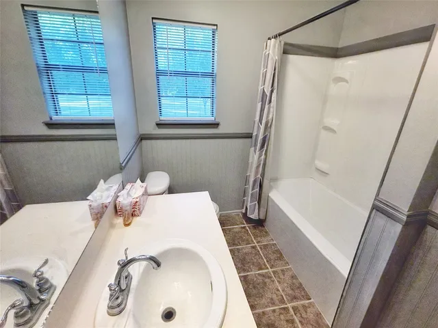 a bath tub sitting next to a white sink and a toilet