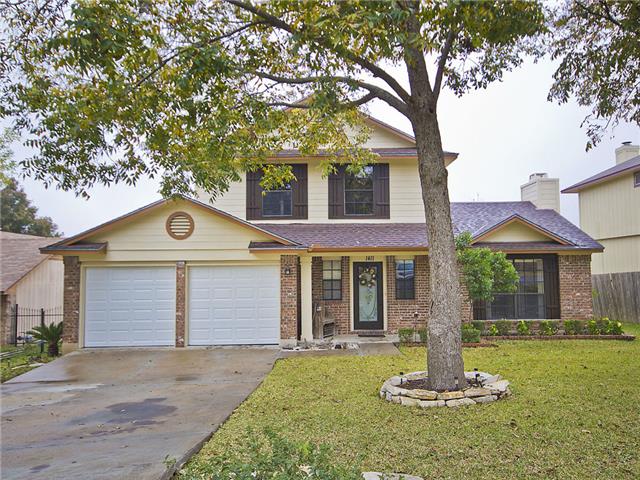 Traditional home with fence, a front lawn, concrete driveway, and brick siding