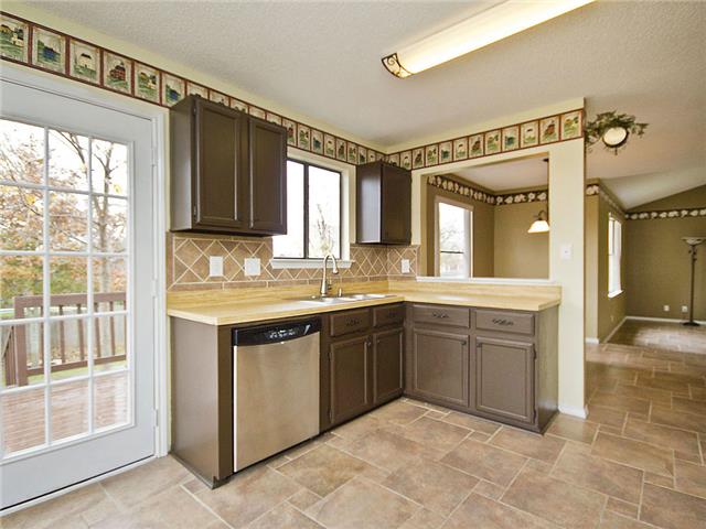 1411 Clearview Loop Round Rock, TX 78664 - Photo 7 of 13 Kitchen featuring tasteful backsplash, light countertops, stone finish flooring, dishwasher, and a sink