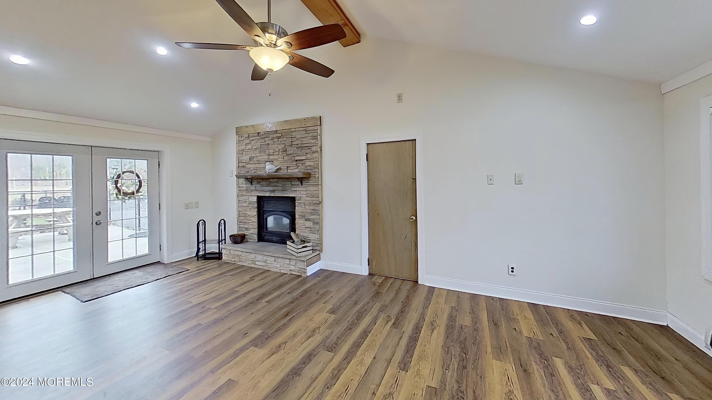 144 Windeler Road Howell, NJ 07731 - Photo 44 of 59 an empty room with windows fireplace and wooden floor