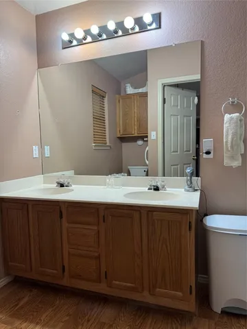 a bathroom with a granite countertop sink a mirror and shower