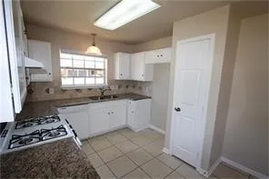 a kitchen with a stove and white cabinets