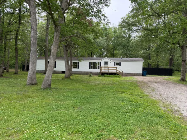 a view of a house with backyard and a tree