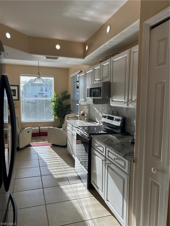 1390 Tiffany Lane, Unit 2302 Naples, FL 34105 - Photo 13 of 37 a kitchen with stainless steel appliances granite countertop a stove a sink and a refrigerator