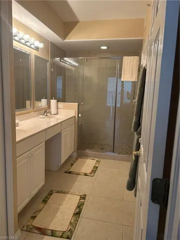 a bathroom with a granite countertop sink a mirror and a shower