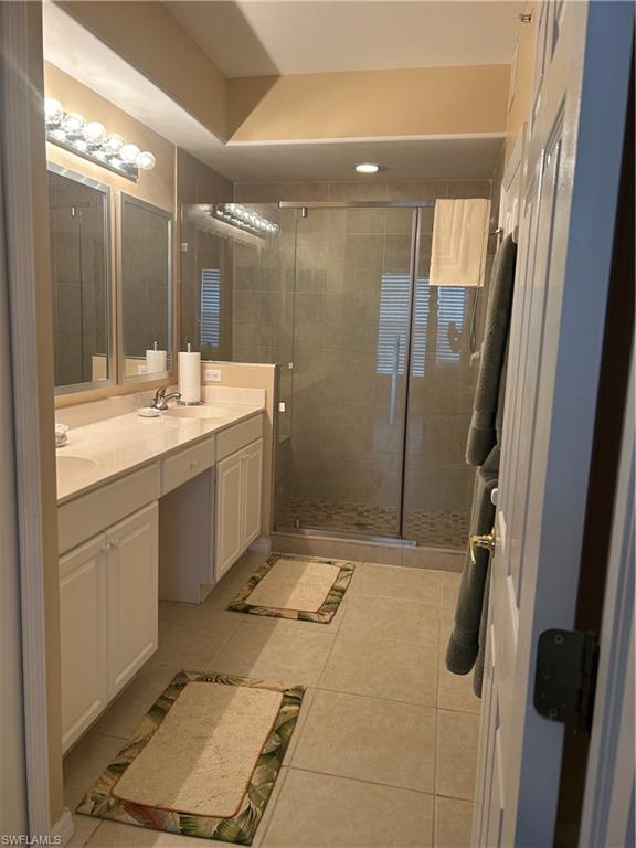 1390 Tiffany Lane, Unit 2302 Naples, FL 34105 - Photo 18 of 37 a bathroom with a granite countertop sink a mirror and a shower