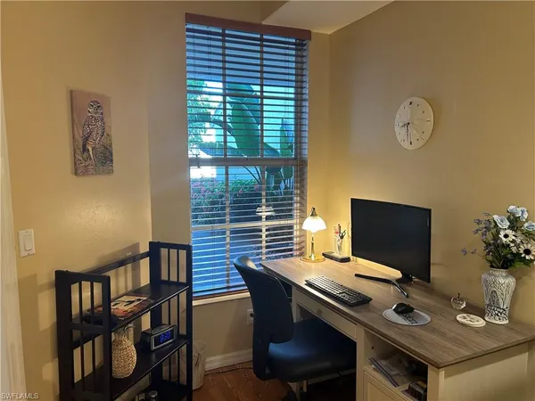 a view of a workspace with furniture and a window