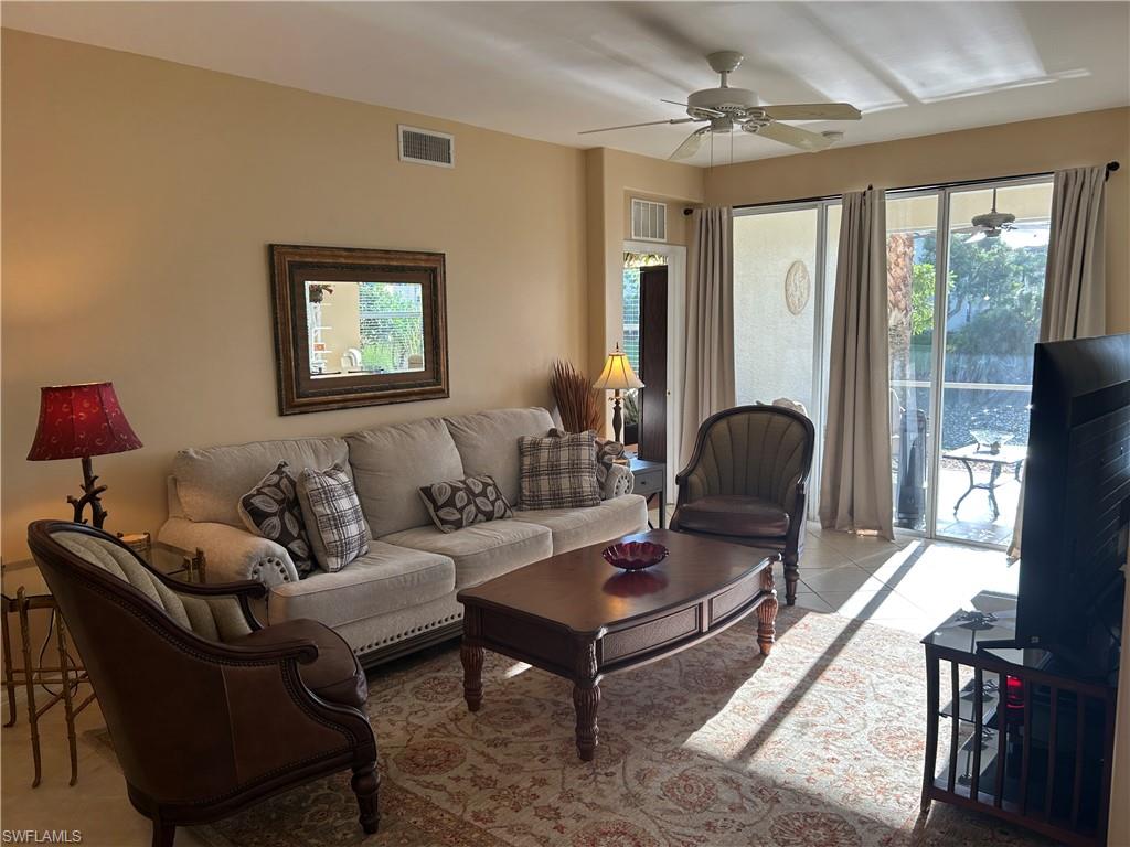 1390 Tiffany Lane, Unit 2302 Naples, FL 34105 - Photo 6 of 37 a living room with furniture a ceiling fan and a window