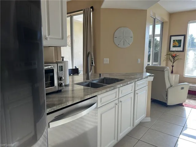 a kitchen with stainless steel appliances granite countertop a sink a stove and cabinets