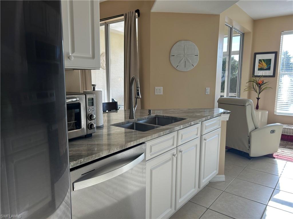 1390 Tiffany Lane, Unit 2302 Naples, FL 34105 - Photo 10 of 37 a kitchen with stainless steel appliances granite countertop a sink a stove and cabinets