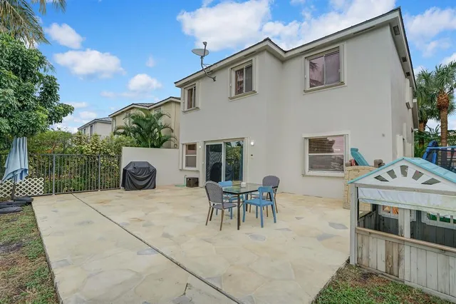 a view of patio with a table and chairs and potted plants
