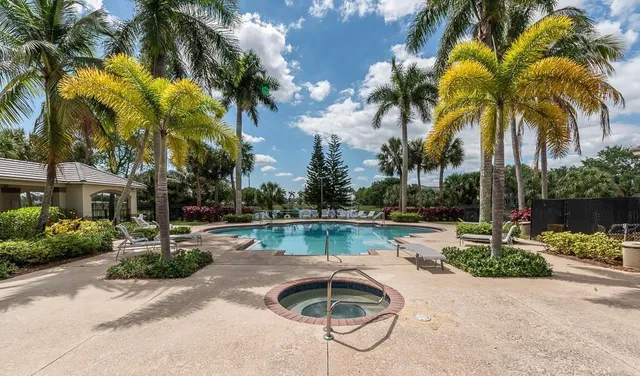 a front view of house with small garden and palm trees