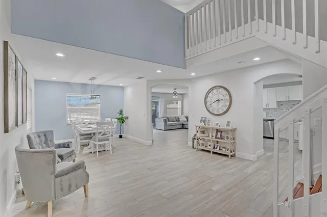 a living room with furniture a clock tv and a window