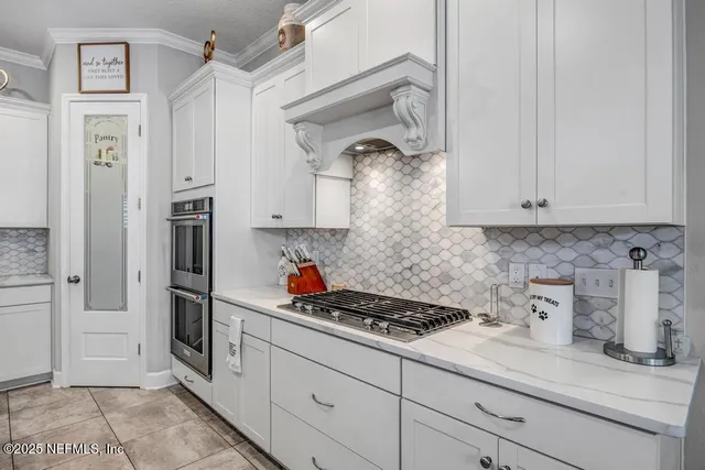 a kitchen with stainless steel appliances granite countertop a stove a refrigerator a oven a sink a table and chairs