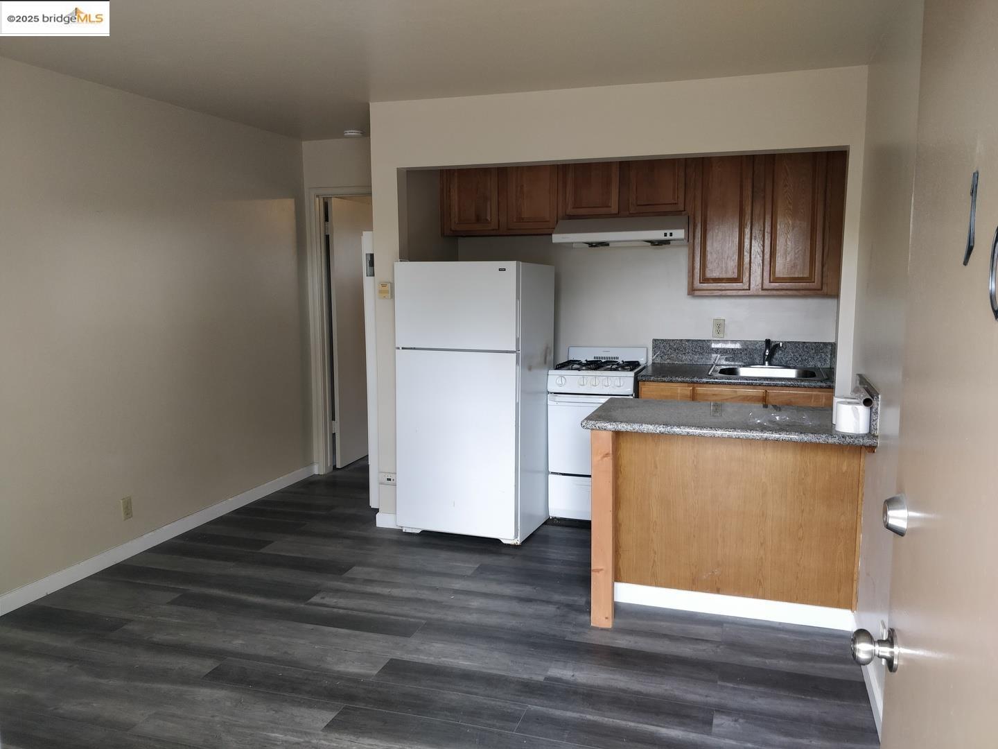 1213 San Pablo Avenue Berkeley, CA 94706 - Photo 12 of 13 a room with wooden floor and white cabinets