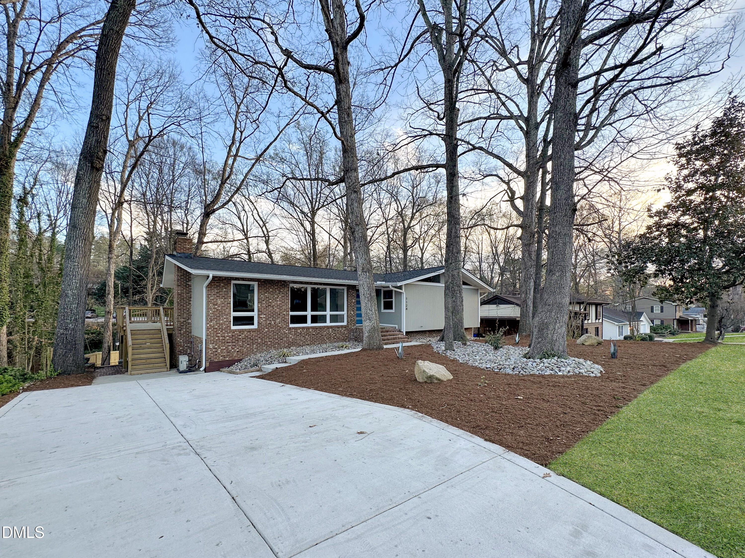a backyard of a house with yard and large tree