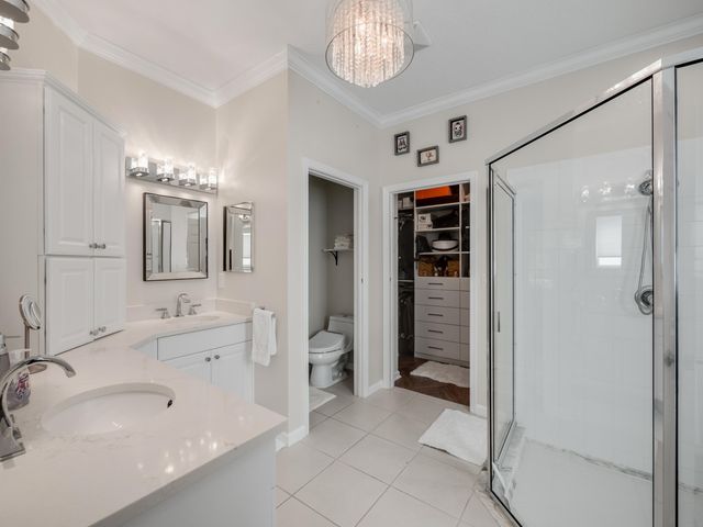 a spacious bathroom with a double vanity sink a large mirror and a shower