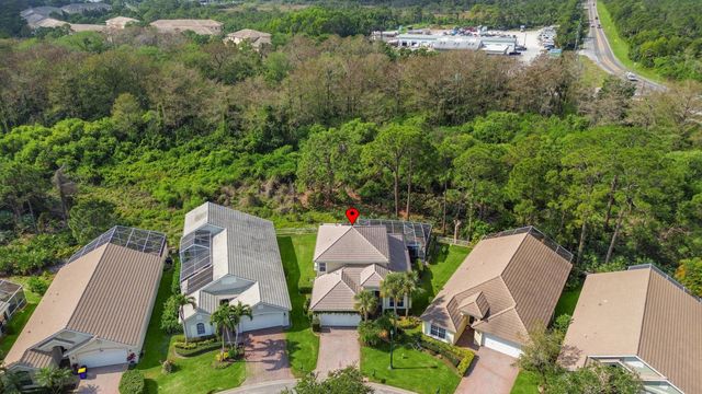 an aerial view of a house with outdoor space and trees all around