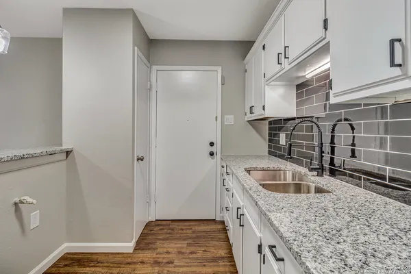 a kitchen with a sink a stove and cabinets