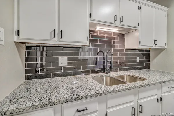 a kitchen with granite countertop a sink and a stove