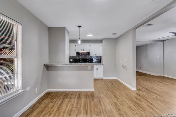 a view of kitchen with wooden floor and electronic appliances