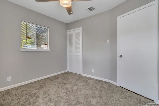an empty room with windows and closet
