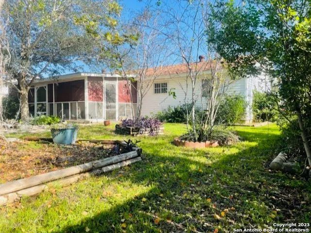 a view of a house with backyard and sitting area