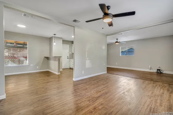 a view of empty room with wooden floor and window