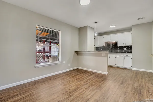 a kitchen with granite countertop a stove a sink and a refrigerator