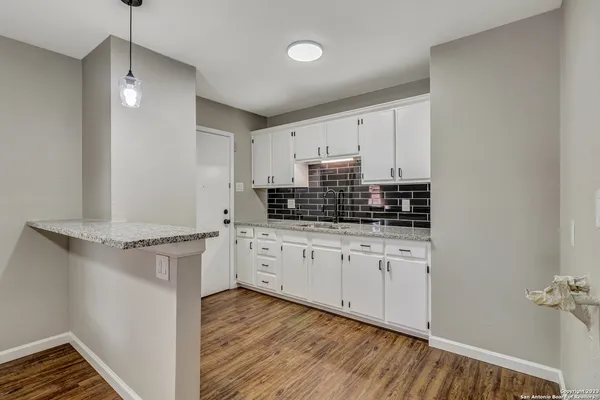 a kitchen with stainless steel appliances white cabinets and wooden floors