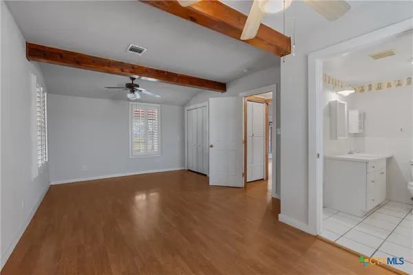 a view of a livingroom with wooden floor and a kitchen